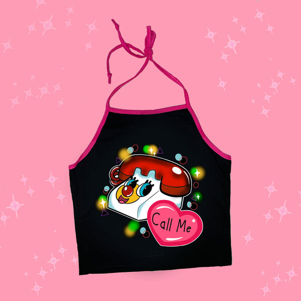 Black halter top with pink trim and thin pink tie straps. Features cartoon image of red and white toy phone with tringle, circle and star shapes in background. Pink heart with black inscription inside that reads "Call Me"'