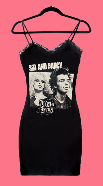 Black thin strap mini dress with black lace trim neckline. Features black and white image of Sid Vicious and his girlfriend Nancy Spungen. Inscription in white reads "SID AND NANCY" and "LOVE KILLS" in black.