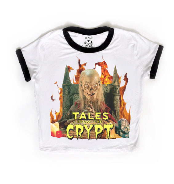White ringer tee with black trim. Features Skeleton sitting on thrown with hands clasped and flames in background. Inscription reads "TALES FROM THE CRYPT" in yellow.