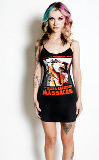Black thin strap mini dress with black lace trim neckline. Features print of man in mask, wearing a bloody suit, holding a chainsaw with both arms over his head. Inscription in red reads "WHAT HAPPENED IS TRUE! NOW THE MOTION PICTURE THAT'S JUST AS REAL!!" and "TEXAS CHAINSAW MASSACRE".