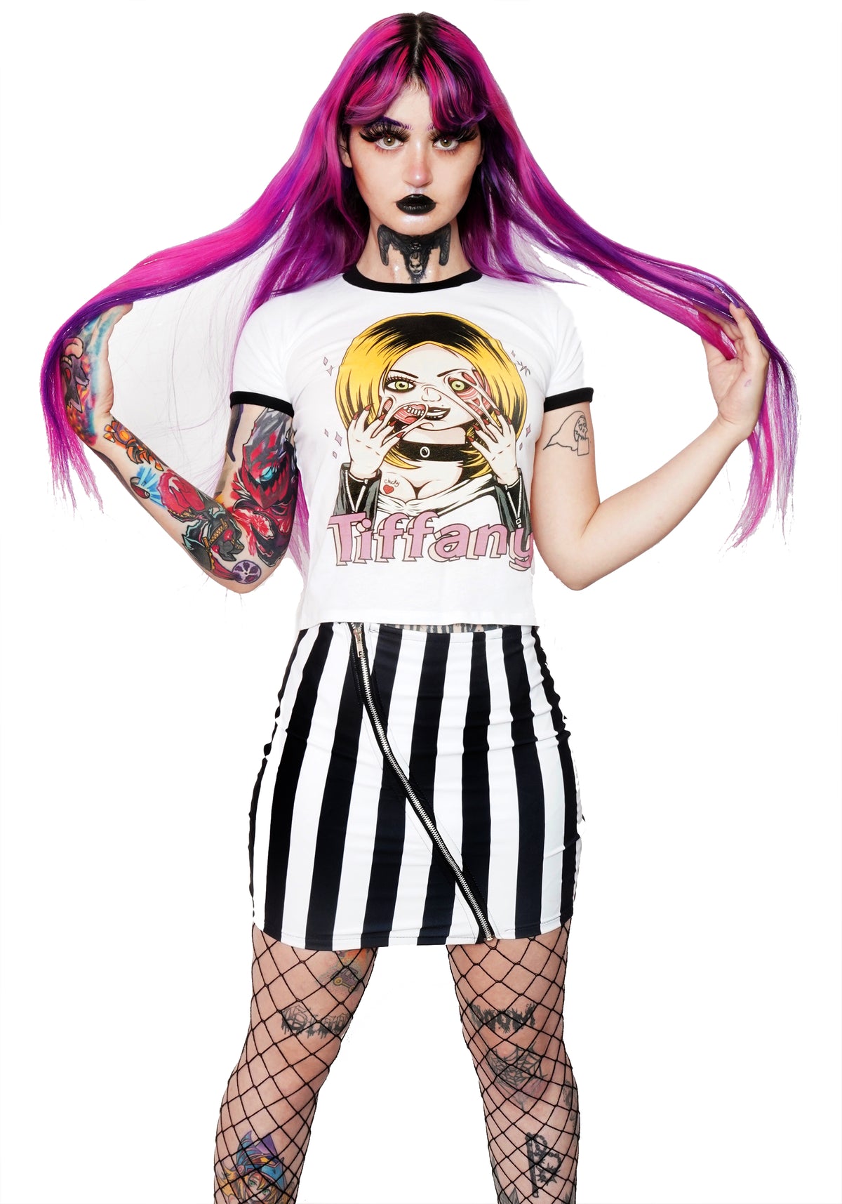 White ringer tee with black trim. Features Tiffany from the movie Bride of Chucky wearing black jacket and choker with her face melting. Black "Chucky" and red heart tattoo on her breast and pink sparkles in background of image. Inscription reads "Tiffany" in pink.