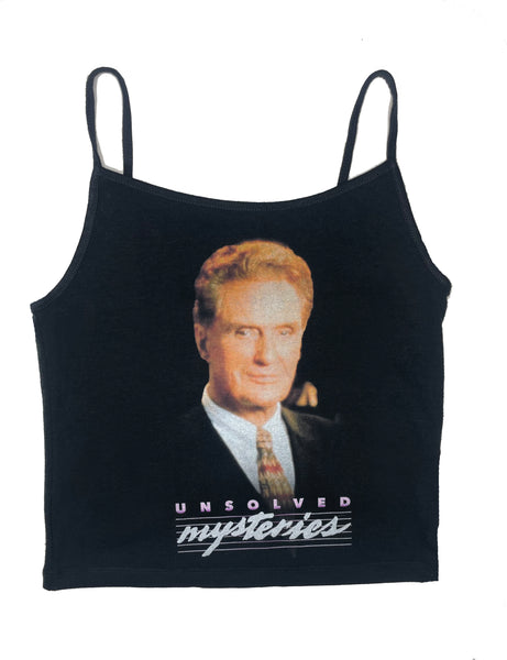 Black thin strap tank top. Features image of the host of Unsolved Mysteries, Robert Stack, smiling wearing a suit and tie. Inscription reads "Unsolved Mysteries" in purple and white.